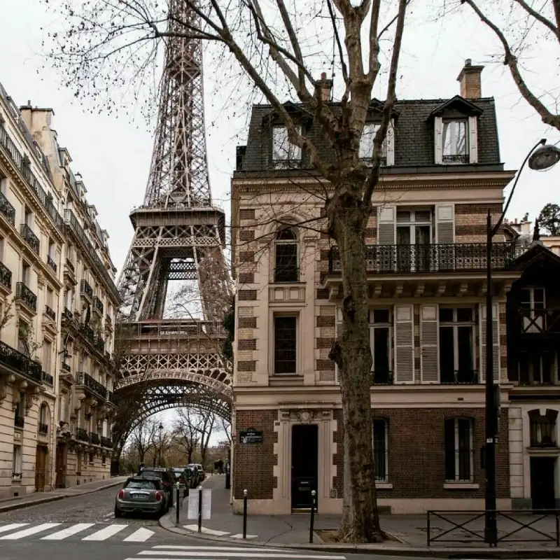 Architecture européenne et rue parisienne avec des voitures garées près de la tour Eiffel